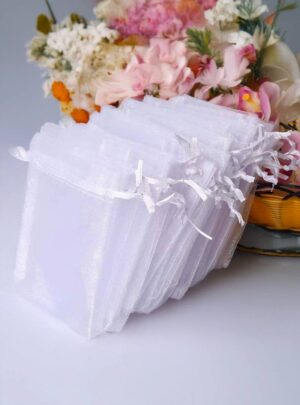 Bolsas de Organza 10x15 cm (Docena) ¡El toque final perfecto para tus recordatorios y detalles especiales! Estas delicadas bolsas de organza vienen en colores blanco y marfil, ideales para presentar souvenirs, mini velas, jabones artesanales, dulces o cualquier detalle personalizado. Su tamaño de 10x15 cm las hace prácticas y versátiles para todo tipo de eventos: bodas, bautizos, baby showers, comuniones y más.