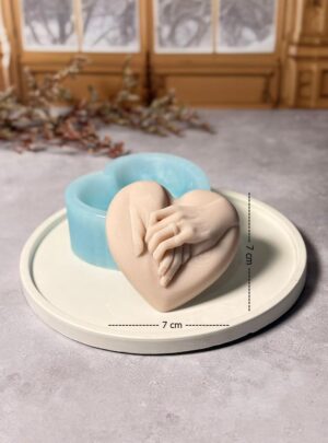 Crea piezas llenas de significado con este hermoso molde de silicona en forma de corazón, diseñado con el detalle de las manos de una pareja mostrando el anillo de compromiso. Es perfecto para elaborar recuerdos, decoraciones o detalles especiales para bodas, compromisos y celebraciones románticas. Gracias a su silicona de alta calidad, el molde permite un desmolde fácil y conserva perfectamente los detalles del diseño, logrando piezas con acabados definidos y profesionales. Su tamaño de 7 x 7 cm es ideal para crear recuerdos decorativos, mini figuras o piezas artesanales para eventos especiales. Características: Material: Silicona de alta calidad Medidas: 7 cm x 7 cm Diseño: Corazón con manos de pareja y anillo de compromiso Flexible y resistente Fácil desmolde Reutilizable y fácil de limpiar Usos recomendados: Ideal para trabajar con yeso, resina, cera, cemento creativo o jabón artesanal, perfecto para crear recuerdos de boda, detalles de compromiso, decoraciones románticas y piezas artesanales personalizadas.