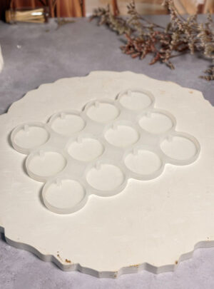 Con cavidades de 3,5 cm de diámetro, es el formato ideal para crear piezas de tamaño estándar que funcionan maravillosamente como llaveros, medallas decorativas o fichas de muestra. Fabricado en silicona de alta resistencia, este molde es compatible tanto con resinas como con yesos, garantizando que cada círculo tenga bordes definidos y una superficie lisa en Arte y Cera.