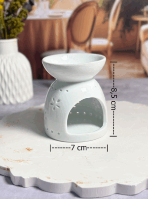 Este mini pebetero cerámico combina funcionalidad y diseño en un formato compacto. Su delicado patrón de flores caladas no solo decora, sino que permite que la luz de la vela se filtre suavemente, creando una atmósfera cálida y relajante mientras difunde tus aromas favoritos.