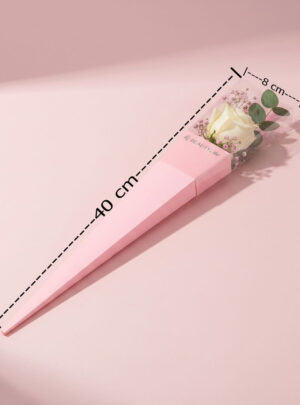 Su acabado en un delicado tono rosado la convierte en la opción predilecta para arreglos de estilo romántico, detalles de aniversario, cumpleaños o San Valentín. Diseñada con un formato alargado tipo estuche, protege la estructura de las flores mientras que su amplio visor transparente de acetato exhibe la belleza, textura y colores de la composición en su interior con total claridad.