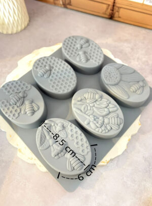 Fabricado en silicona flexible de grado alimenticio y alta durabilidad, este molde cuenta con 6 cavidades individuales decoradas con delicados motivos de abeja y textura de panal. Es perfecto para jabones de glicerina o saponificados a base de miel, avena, avellana o cera de abejas, logrando pastillas ergonómicas de 80 gramos por pieza.